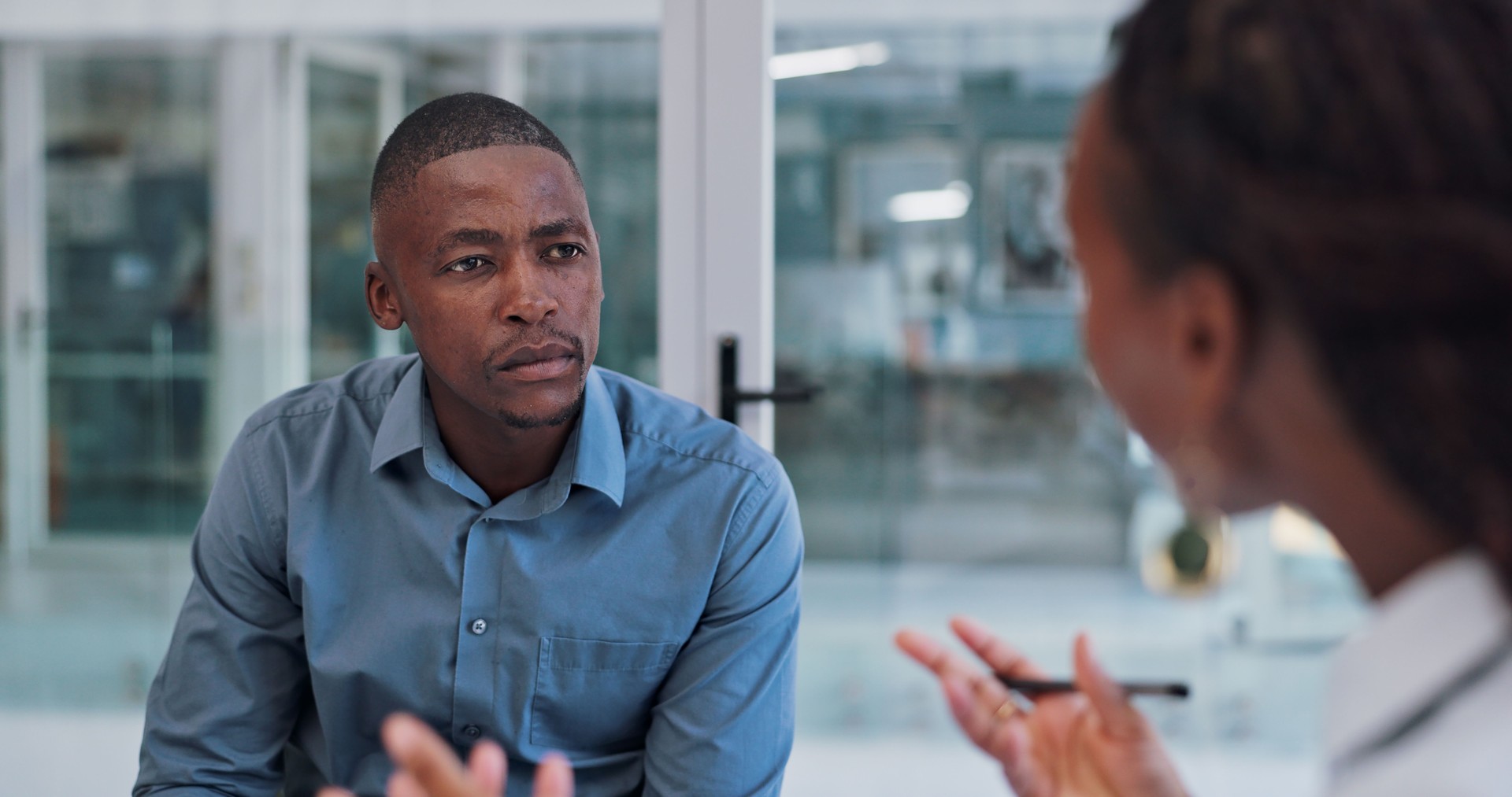 Black man, serious and job interview for career growth with question, hiring and employee. Boardroom, boss and candidate in company as hr manager with corporate opportunity, commitment and discussion